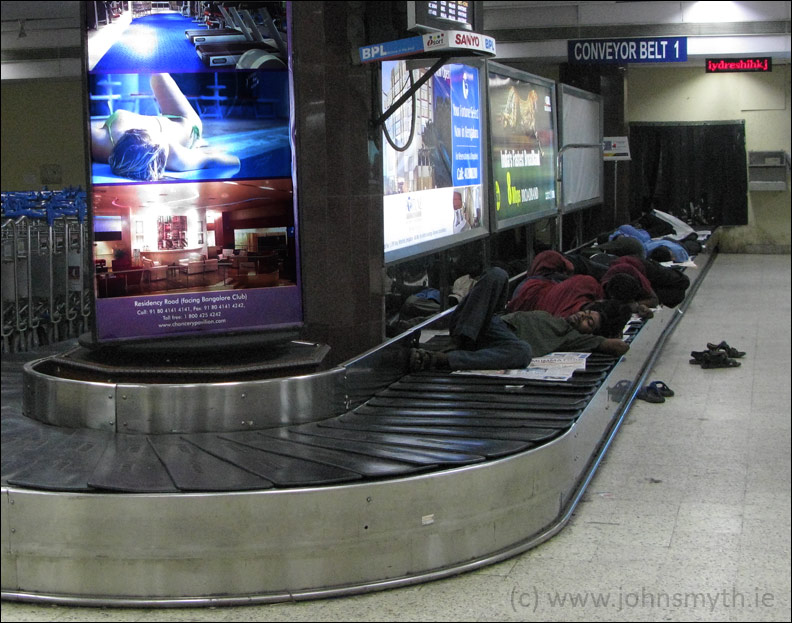 Baggage handlers resting between shifts at Bangalore's Hindustan airport, in India